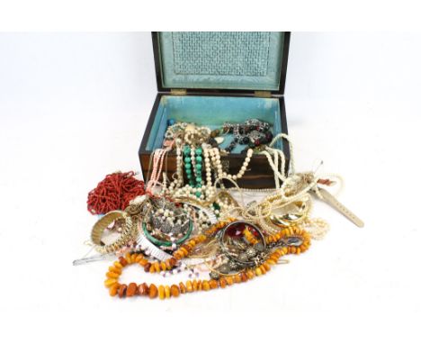 An assortment of jewellery. Including necklaces, bracelets, a bangle, etc. contained within an antique hardwood jewellery box