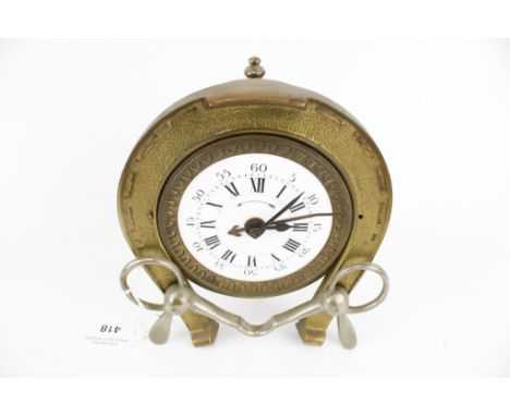 A horse shoe alarm clock. With white enamel dial, Roman and Arabic numerals, horseshoe and bit decoration and spur support, s