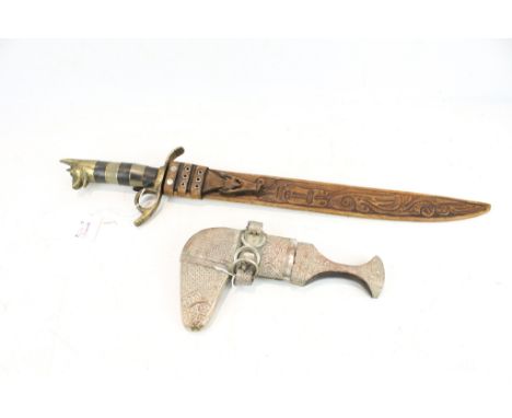 Two collectable knives. Including a Jabiya and a long knife with a dog head pommel with a tooled leather scabbard, max. 60cm 