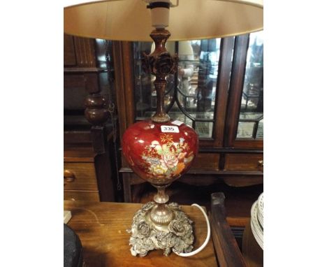 Red and floral decorated table lamp on metal rose patterned base with cream shade 