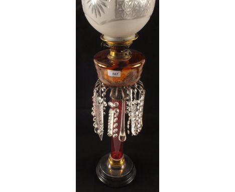 An oil lamp with Cranberry column and engraved Amber glass bowl with droplets