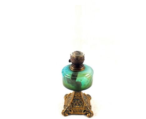 An Iron base and green glass oil lamp