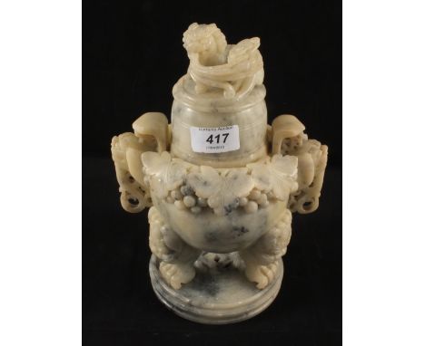 A Chinese carved soapstone lidded jar with Kylin finial and claw feet on stand, height 10"