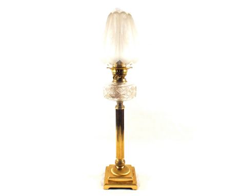 A gilt metal oil lamp with reeded column with cut glass font and etched globe