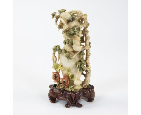 A perfume bottle in ivory with around a carved decor of whimsical tree trunks, foliage and cranes, slightly colored and stand