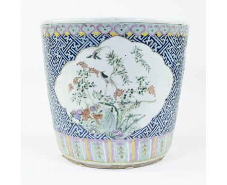 A large and fine porcelain planter decorated in polychrome enamels of orchids, peonies and birds on a ground of geometric fig