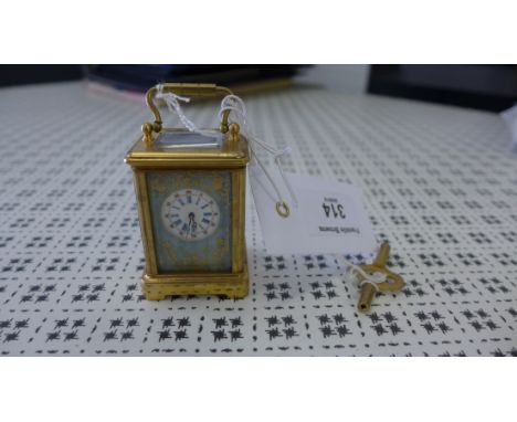 Miniature brass and porcelain plaque carriage clock, the enamel dial with blue Roman numerals, complete with key, 6.5 cm high