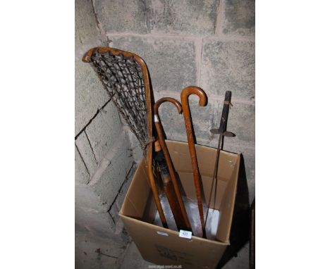 A Lacrosse stick, cricket bat, two walking sticks and a fencing sword.