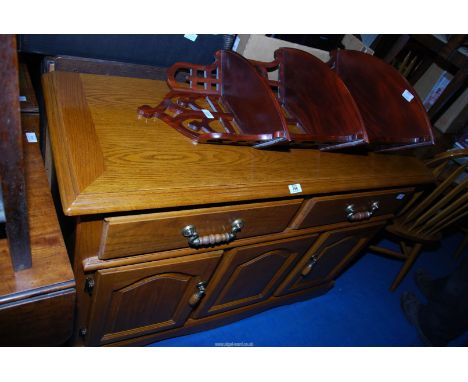 An Oak framed sideboard with two drawers and two lower cupboards, 49" x 18" x 33" high and a fret-worked backed wall-shelf/et