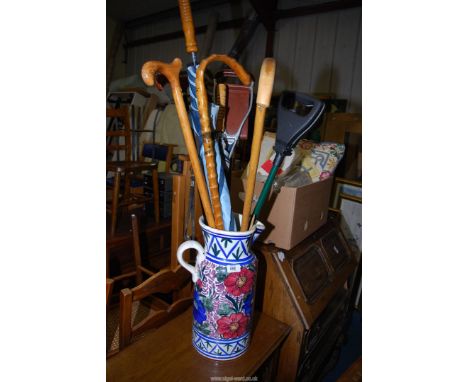 A ceramic jug, shooting stick, walking sticks and umbrellas.