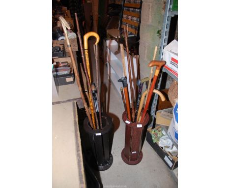 A quantity of walking sticks, thumbsticks and crook in two stick stands.