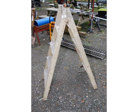 A wooden two way step ladder.