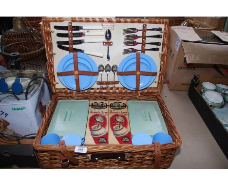A wicker picnic hamper 'Coracle' with setting for four people, two thermos flasks, etc.
