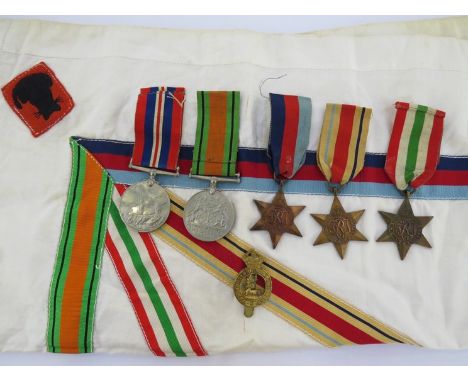 A WWII medal group of five consisting of Africa, Italy &amp; 1939-45 stars, defence &amp; war medal together with embroidered