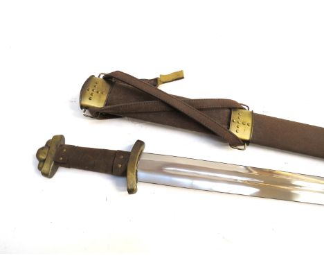 A replica of a Viking 3-lobe pommel sword together with scabbard. Stainless steel blade with brass fixtures and a suede/suede