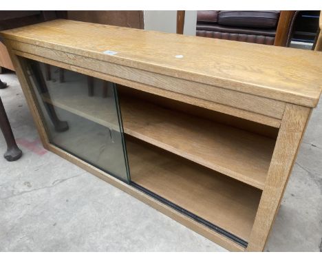 A LIGHT OAK BOOKCASE WITH GLASS SLIDING DOORS 