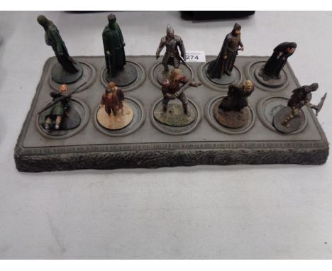 A COLLECTION OF TEN LORD OF THE RINGS FIGURES ON A DISPLAY STAND 