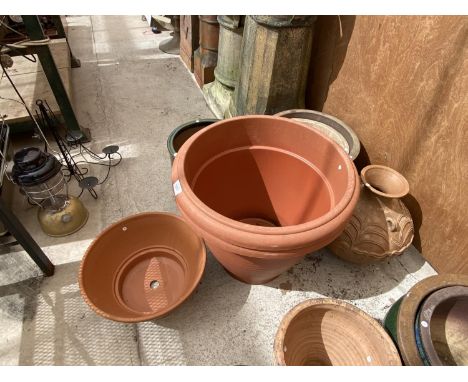 AN ASSORTMENT OF CERAMIC AND PLASTIC PLANTERS OF VARIOUS SIZES 