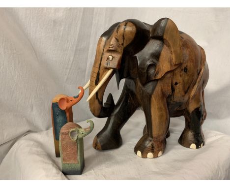A LARGE CARVED HEAVY HARD WOOD ELEPHANT (H: APPROX. 30CM) AND TWO CERAMIC ELEPHANT ITEMS 