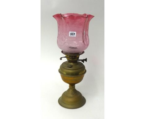 Brass oil lamp with cranberry glass shade, 45cm