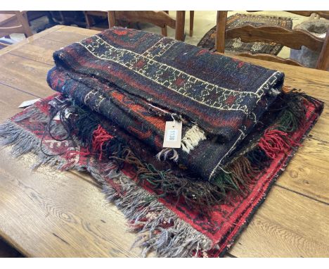 An Afghan red ground rug with stylised mihrab and iris motifs, a small Afghan rug and three carpet panel cushion covers, larg