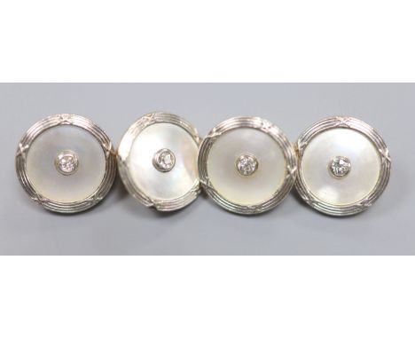 A pair of yellow metal, mother of pearl and diamond disc cufflinks, diameter 14mm, gross weight 8.6 grams.CONDITION: One of t