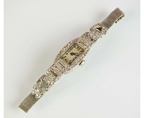 An Art Deco platinum and diamond cocktail wristwatch, the canted oblong silvered dial with black Arabic numerals set within a