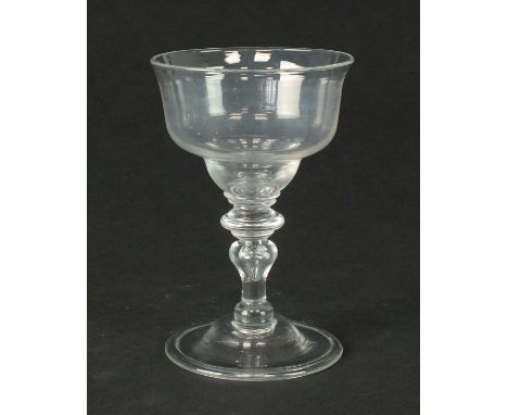 An early 18th-century champagne or sweetmeat glasscirca 1720-30the flared double ogee bowl set above a baluster stem with a p