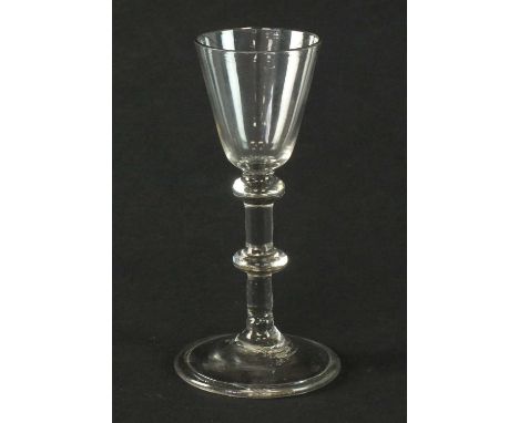 A mid-18th century light baluster wine glass circa 1740the pointed round funnel bowl above a baluster stem with two annular k