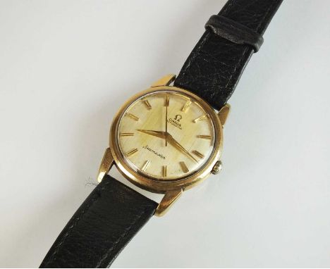 A Gentleman's 9ct gold Omega Seamaster automatic wristwatch, the silvered dial with batons, with attached black leather strap