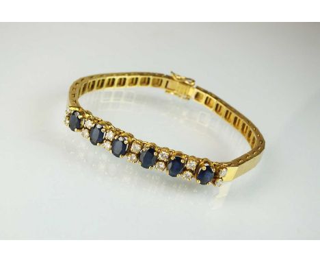 A sapphire and diamond line bracelet, designed as a row of six oval mixed cut sapphires each interspersed with a pair of bril