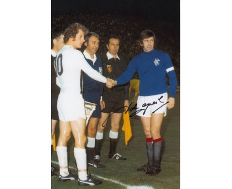 Autographed JOHN GREIG 12 x 8 photo - Col, depicting Borussia Monchengladbach captain Herbert Wimmer shaking hands with his R