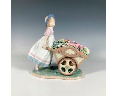 A glossy sculpture of a girl pushing a cart laden with delicate, intricate, colorful flowers. Select Dealers 1997. Signature 