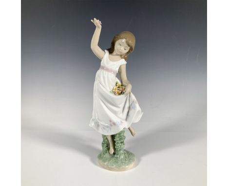 A glossy figure of a young girl using her dress to hold her flowers. 1999 Event Piece. Lladro backstamp. This item has its or
