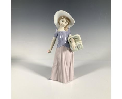 A glossy figure of a young girl holding a picnic basket and a pink flower. November 15, 1997 Event Piece. Lladro backstamp. T