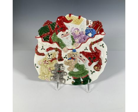 A colorful festive plate featuring an intricate high-relief design depicting a couple of elves filling up a bag with gifts. F