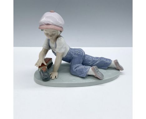 Little boy playing with a toy train. Glossy finish. Lladro backstamp. Artist: Antonio RamosIssued: 1992 - 1995Dimensions: 7.5