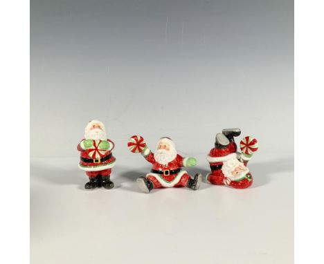 This three piece set of glossy figures depict Santa Claus in jolly, whimsical poses, each holding peppermint candies. Fitz an