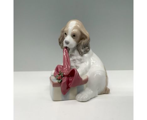 Glossy finish. Figure of a puppy with a red ribbon, sitting next to a gift box. Lladro backstamp. This item has its original 