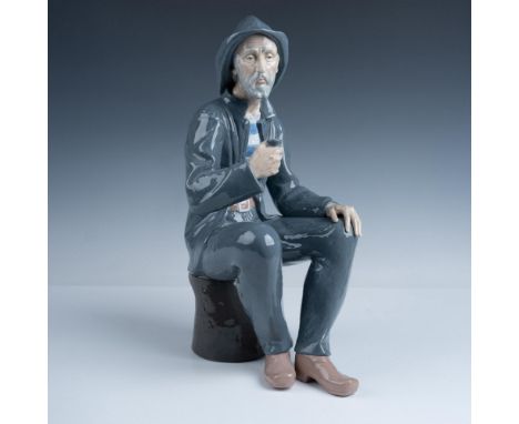 Lovely large figure featuring a bearded man taking a rest on a seat as he smokes a pipe. Nao by Lladro backstamp. Issued: 197