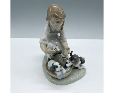 Glossy porcelain. Features a little girl playing with puppies in a basket. Lladro backstamp. Artist: Francisco PolopeIssued: 