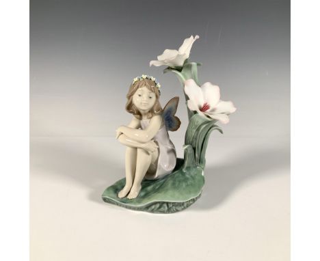 A glossy figure of a fairy sitting by a pair of matte finish blooming flowers. Lladro backstamp. This item has its original b