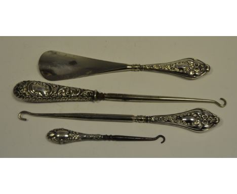 An Edwardian silver hafted shoe hook, the haft embossed with leafy scrolls, Chester 1898; another, Chester,  1908;  a similar