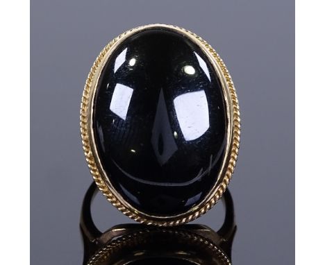 A large 9ct gold onyx panel dress ring, ropetwist surround and openwork shoulders, hallmarks Birmingham 1990, setting height 