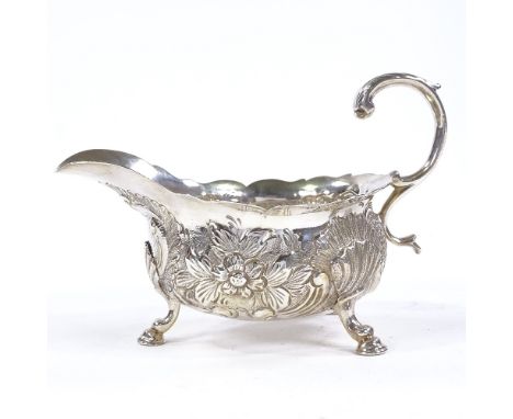 A George II silver sauce boat, relief embossed floral and foliate decoration with acanthus leaf C handle and 3 hoof feet, ind