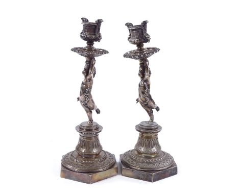 A pair of Victorian Elkington plate candlesticks supported by cherubs, height 27cm One stick has been broken at the ankle of 