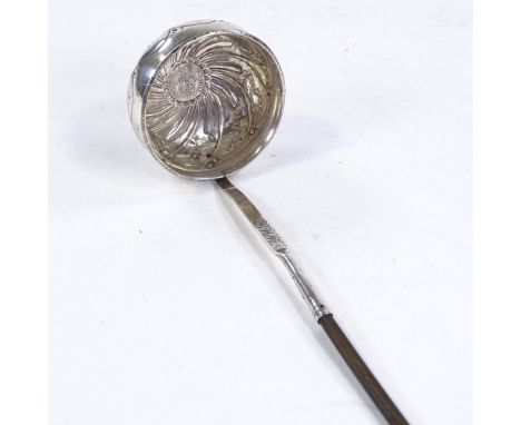 A George III silver toddy ladle, relief embossed twisted floral decoration with inset coin bowl and twisted whale bone handle