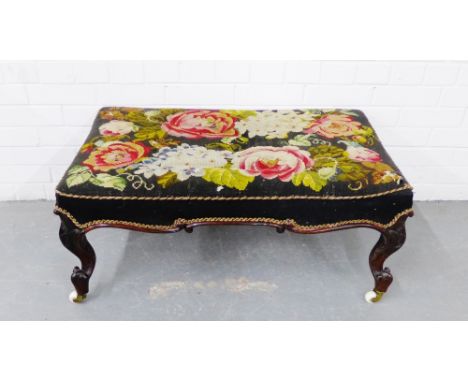 A 19th century rosewood framed footstool with tapestry top raised on scrolling supports terminating in ceramic castors,  38 x