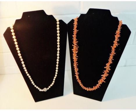 A strand of cultured pearls with a 14 carat gold clasp together with a vintage strand of coral beads (2)  