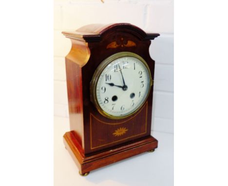 An early 20th century mahogany and inlaid cased mantle clock, the enamel dial with Arabic numerals raised on four bun feet, 2